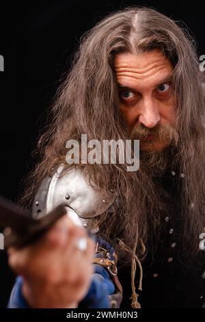 Composition verticale. Portrait d'un homme charismatique habillé en chevalier médiéval avec une épée lors d'une reconstitution historique Banque D'Images