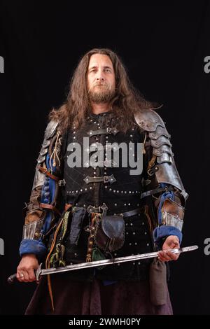 Composition verticale. Portrait d'un homme charismatique habillé en chevalier médiéval lors d'une reconstitution historique Banque D'Images