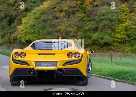 Luxembourg City, Luxembourg - Focus sur une Giallo Triplo Strato Ferrari F8 Tributo garée dans une rue à la campagne. Banque D'Images