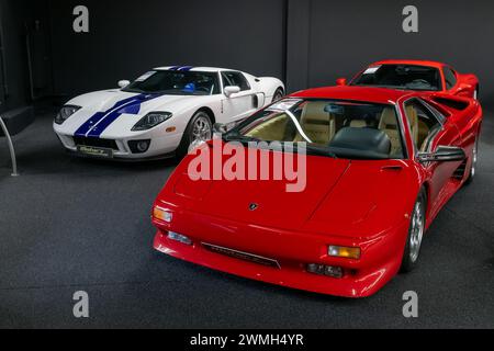 Luxembourg City, Luxembourg - Focus sur une Lamborghini Diablo rouge et une Ford GT blanche dans un showroom. Banque D'Images