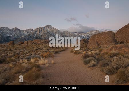 Un sentier de randonnée traverse la région des Alabama Hills dans l'est de la Californie en direction du Mont Whitney et de la chaîne de montagnes de la Sierra Nevada. Banque D'Images