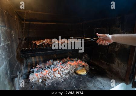 Barbecue argentin typique ou asado. main Banque D'Images