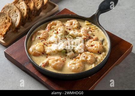 Fondue aux crevettes à la crème épicée plat coréen pâtes briques crème rosé crevettes Tteokbokki Mac et fromage pommes de terre tomates pâtes aux viandes Banque D'Images