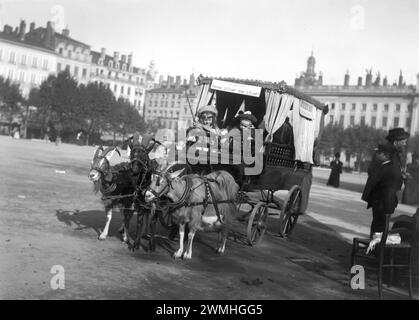 Une calèche tirée par des chevaux avec des enfants traverse un lieu de la ville lyonnaise, au début du XXe siècle. Vieille photo numérisée à partir de plaques de verre. Banque D'Images