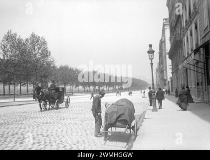 Quelqu'un avec un chapeau melon vendant des meubles dans une rue pavée de Paris. Début du XXe siècle. Ancienne photo restaurée. Banque D'Images