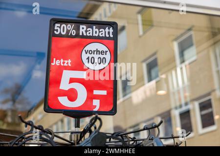 Un présentoir avec 50% de réduction se dresse à l'extérieur devant un magasin de mode en Allemagne. Banque D'Images