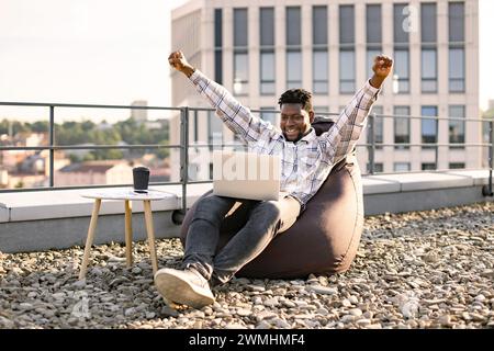 Portrait d'un homme africain buvant du café tout en levant la main vers le haut. Banque D'Images