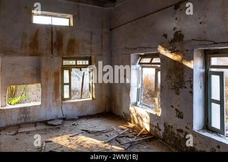 Intérieur d'un bâtiment démoli avec des fenêtres brisées dans la ville abandonnée d'Al Jazirah Al Hamra à Ras Al Khaimah, Émirats arabes Unis. Banque D'Images