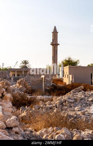 Ruiné abandonné Al Jazirah Al Hamra ville hantée à Ras Al Khaimah, Émirats arabes Unis, avec des bâtiments démolis et une mosquée avec minaret. Banque D'Images