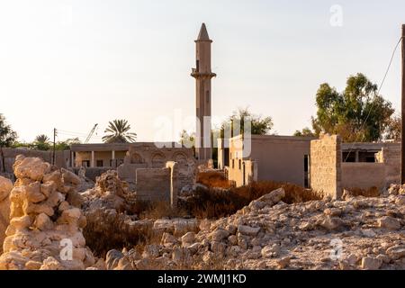 Ruiné abandonné Al Jazirah Al Hamra ville hantée à Ras Al Khaimah, Émirats arabes Unis, avec des bâtiments démolis et une mosquée avec minaret. Banque D'Images