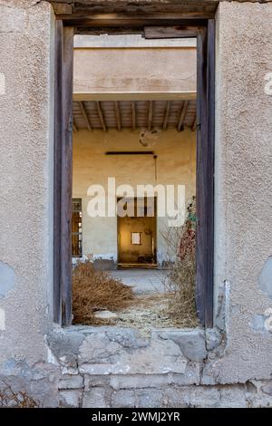 Tunnel symétrique de cadres de porte dans des bâtiments abandonnés à Al Jazirah Al Hamra ville hantée à Ras Al Khaimah, Émirats arabes Unis. Banque D'Images