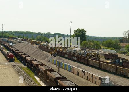 Lyon, France - 16 mai 2023 : plusieurs rangées de trains de marchandises sont chargées de diverses marchandises dans un vaste chantier de triage. La journée est claire et ensoleillée, spectacle Banque D'Images