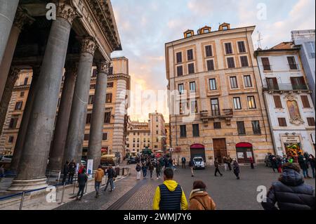 Rome, Italie - 22 décembre 2022 : vue captivante sur une rue romaine bordée de bâtiments historiques et animée de piétons au coucher du soleil Banque D'Images