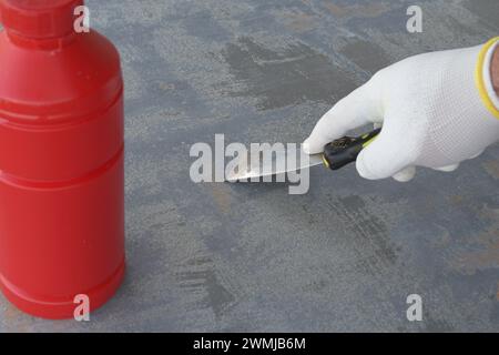 Utilisation de produits chimiques spéciaux pour enlever la vieille peinture d'une surface en bois d'un objet Banque D'Images