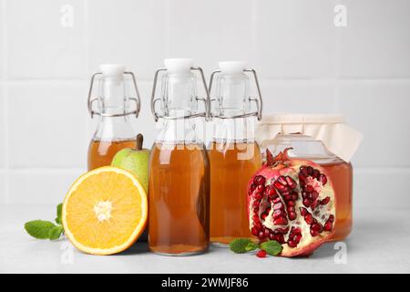 Savoureux kombucha, fruits frais et menthe sur table blanche Banque D'Images