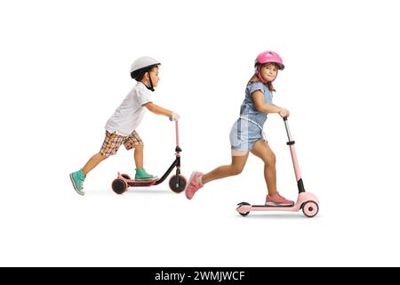 Enfants sur scooters poussés isolés sur un fond blanc Banque D'Images