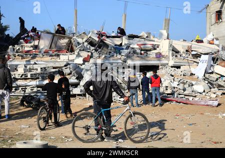 Gaza. 26 février 2024. Les gens se rassemblent dans un bâtiment détruit après une frappe aérienne israélienne dans la ville de Rafah, dans le sud de la bande de Gaza, le 26 février 2024. Le bilan palestinien des attaques israéliennes en cours dans la bande de Gaza est passé à 29 782 morts, a déclaré lundi le ministère de la santé dirigé par le Hamas dans un communiqué de presse. Crédit : Khaled Omar/Xinhua/Alamy Live News Banque D'Images