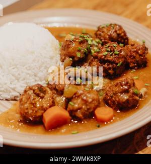Assiette de boulettes de viande avec riz et carottes en sauce Banque D'Images