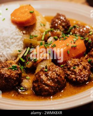 Assiette de boulettes de viande avec riz et carottes en sauce Banque D'Images