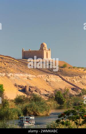 N/A ; bateau navigant dans un estuaire du Nil sous une mosquée près des tombeaux des nobles, Assouan, Egypte Banque D'Images