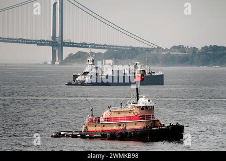 Remorqueur et barge dans la partie supérieure de la baie de New York avec Verrazzano-Narrows Bridge et Staten Island en arrière-plan< New York City, New York, USA Banque D'Images