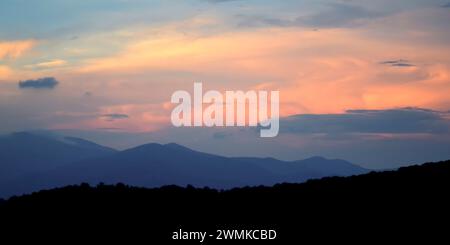 Vue sur la montagne silhouette contre un ciel bleu avec des nuages roses au crépuscule dans les Blue Ridge Mountains, Flattop Mountain, Fairview Banque D'Images