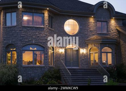 Façade luxueuse en pierre taillée Havane de deux étages illuminée au crépuscule. Banque D'Images