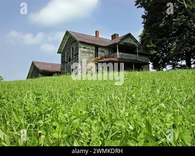 Maison de ferme abandonnée sur une colline herbeuse avec un ciel bleu dans l'ouest de la Caroline du Nord ; Caroline du Nord, États-Unis d'Amérique Banque D'Images