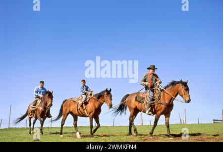 Rancher, son fils et son petit-fils à cheval ; Howes, Dakota du Sud, États-Unis d'Amérique Banque D'Images