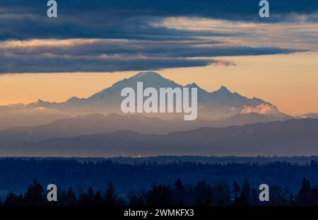 Vue silhouette du Mont Baker couvert de neige à Washington, prise depuis Surrey, Colombie-Britannique avec la lueur dorée du crépuscule illuminant le ... Banque D'Images