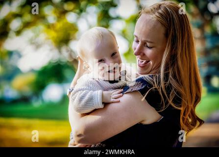 Portrait extérieur d'une mère passant du temps de qualité avec son fils qui a le syndrome de Down dans un parc municipal pendant une journée d'automne ; Leduc, Alberta, Canada Banque D'Images