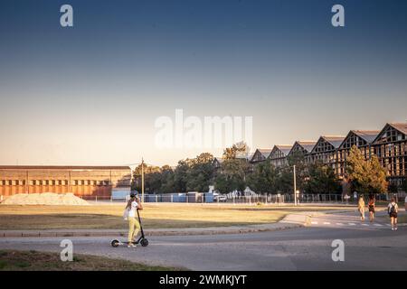 Photo d'une fille ayant un appel sur un smartphone dans la zone industrielle de Belgrade, serbie, alors qu'elle conduisait un scooter électrique. Banque D'Images