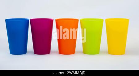 Gobelets en plastique de différentes couleurs sur fond blanc Banque D'Images