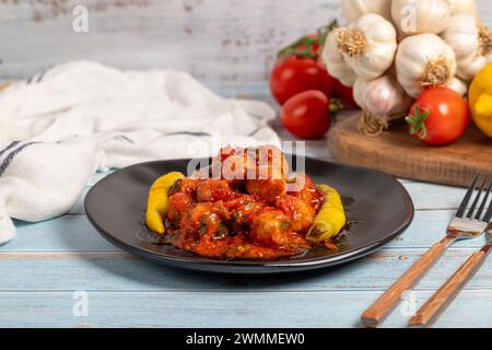 Boulettes de viande d'Alep. Hors-d'œuvre. Petites boulettes de viande avec de la pâte de tomate sur un fond en bois bleu Banque D'Images