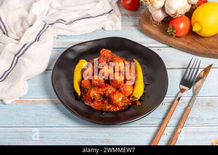 Boulettes de viande d'Alep. Hors-d'œuvre. Petites boulettes de viande avec de la pâte de tomate sur un fond en bois bleu Banque D'Images