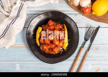 Boulettes de viande d'Alep. Hors-d'œuvre. Petites boulettes de viande avec de la pâte de tomate sur un fond en bois bleu. Vue de dessus Banque D'Images
