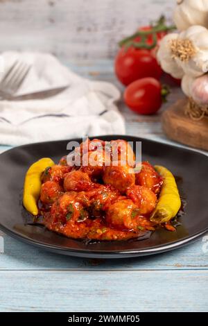 Boulettes de viande d'Alep. Hors-d'œuvre. Petites boulettes de viande avec de la pâte de tomate sur un fond en bois bleu. Gros plan Banque D'Images