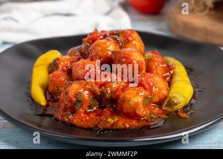 Boulettes de viande d'Alep. Hors-d'œuvre. Petites boulettes de viande avec de la pâte de tomate sur un fond en bois bleu. Gros plan Banque D'Images