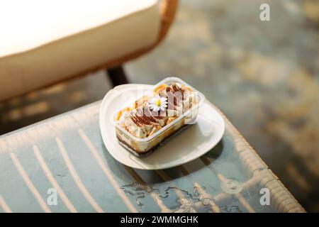 Banoffee dans une tasse en plastique transparent sur une table en verre dans un café. Banque D'Images