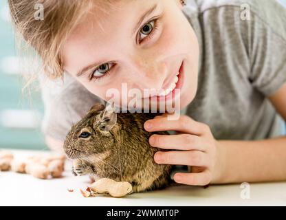 Portrait de la jeune fille avec écureuil et noix de dégu, gros plan. Banque D'Images