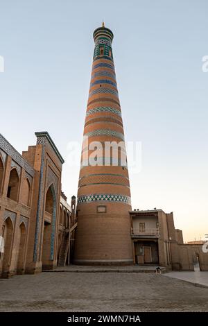 Emblématique Islam Khoja Minaret contre le ciel bleu dans la vieille ville d'Itchan-Kala. Banque D'Images