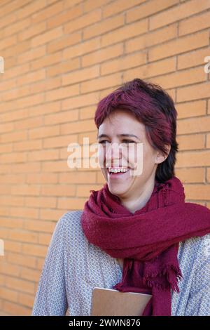 Portrait d'un jeune étudiant souriant avec une coiffure unique tenant un cahier Banque D'Images