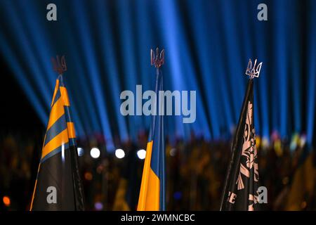 Non exclusif : LVIV, UKRAINE - 23 FÉVRIER 2024 - des armoiries ukrainiennes décorent des mâts de drapeau alors que le public rend hommage aux défenseurs de Banque D'Images