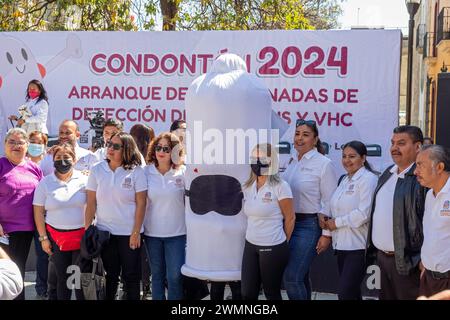 Oaxaca, Mexique - les agents de santé posent pour des photos avec une personne portant un costume de préservatif dans le cadre de leur campagne contre les maladies sexuellement transmissibles Banque D'Images