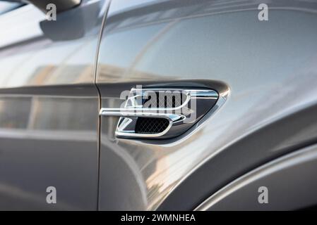 Évent d'aile décoratif extérieur de Bentley Bentayga argenté. Vue rapprochée du détail chromé sur le côté de la voiture - insert chromé en forme de lettre B. Banque D'Images