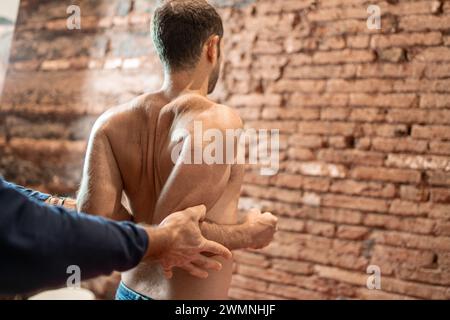 L'invention concerne un physiothérapeute effectuant une manipulation thérapeutique manuelle sur le dos d'un patient, en se concentrant sur la colonne vertébrale pour l'alignement et le soulagement de la douleur. Banque D'Images