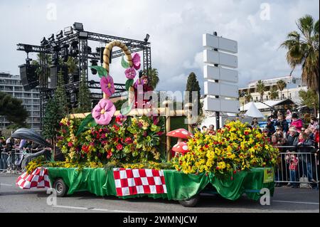 Les femmes sur les chars de carnaval jettent des fleurs à la foule à Nice Carnival Flower Battle -24 février 2024 Banque D'Images