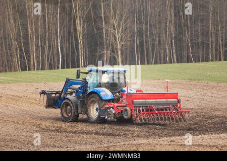 Tracteur agricole avec semoir dans le champ, jour de printemps, Pologne orientale Banque D'Images