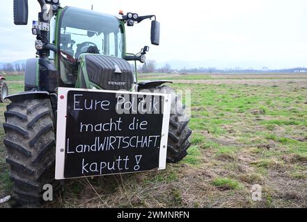 Fribourg, Allemagne. 27 février 2024. Les agriculteurs manifestent avec des tracteurs et des banderoles contre la politique agricole du gouvernement allemand lors d'une cérémonie inaugurale pour le nouveau grand district de Dietenbach à Fribourg. Crédit : Bernd Weißbrod/dpa/Alamy Live News Banque D'Images