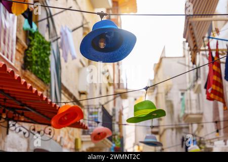 Bari, Italie - 22 septembre 2023 : chapeaux colorés comme lampes suspendues dans la vieille ville de Bari en Italie en été. Site touristique *** Bunte Hüte als Lampen hängen in der Altstadt von Bari in Italien im Sommer. Touristenattraktion Banque D'Images